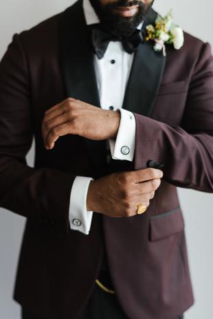 Toronto Wedding Details Photography. Groom getting dressed in his black and burgundy suit, black bowtie and white collared shirt.