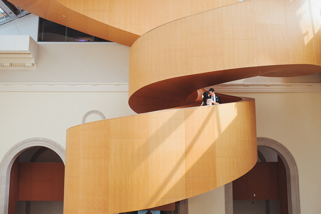 AGO Toronto Wedding Photography. Creative photo session with the couple standing on the iconic Frank Ghery designed AGO staircase.
