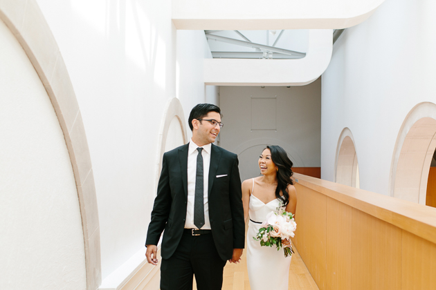 AGO Toronto Wedding Photography. The bride and groom, now husband and wife are phootgraphed walking hand in hand.