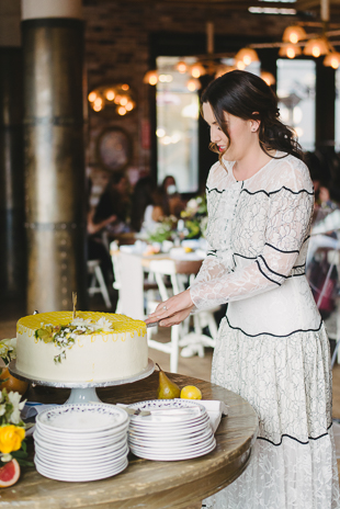 A bride-to-be is cutting her cake on a garden-inspired bridal shower