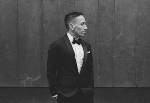 A groom posing for formal portraits besides Four Seasons Hotel 