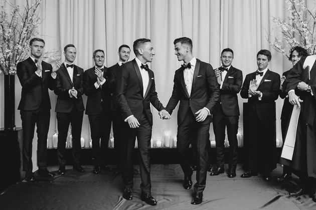 Grooms exiting the ceremony hall at their Four Seasons Hotel wedding