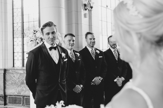 Groom's reacting to the bride walking down the aisle at the ceremony altar