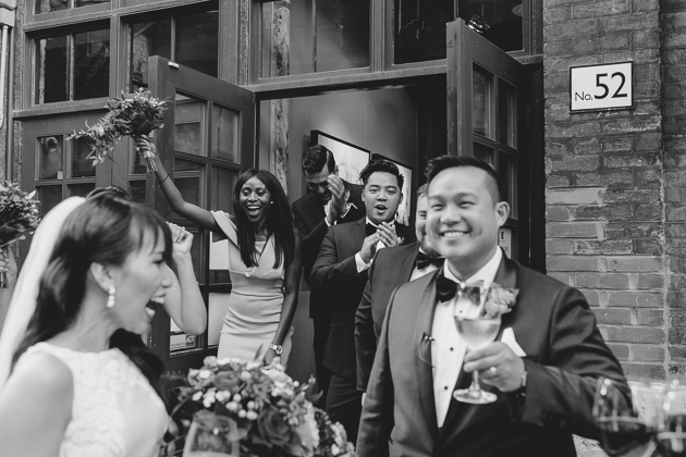 Bridesmaids and groomsmen cheering for the couple after the ceremony