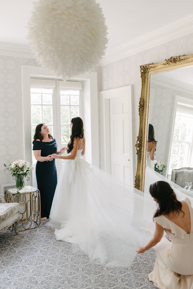 A bride's putting on her wedding dress at Graydon Hall Manor