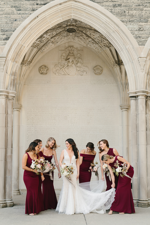 Bridesmaids helping the bride to flare out her dress
